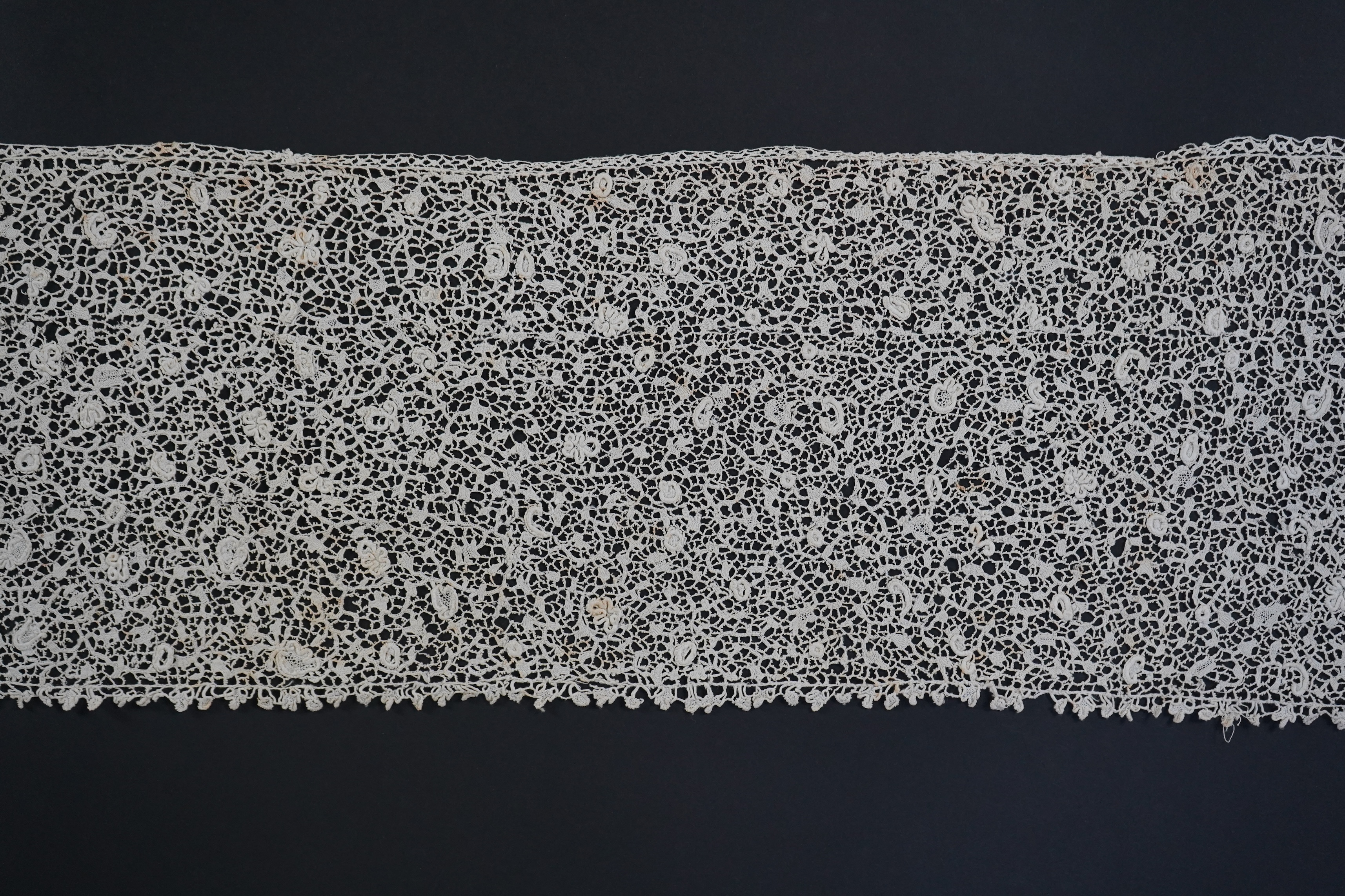 A late 17th century wide flounce of Point de France needle lace, together with a narrower flounce, both with raised elements of the design in the style of Point de Rose, but less so. This lace was very popular with the F